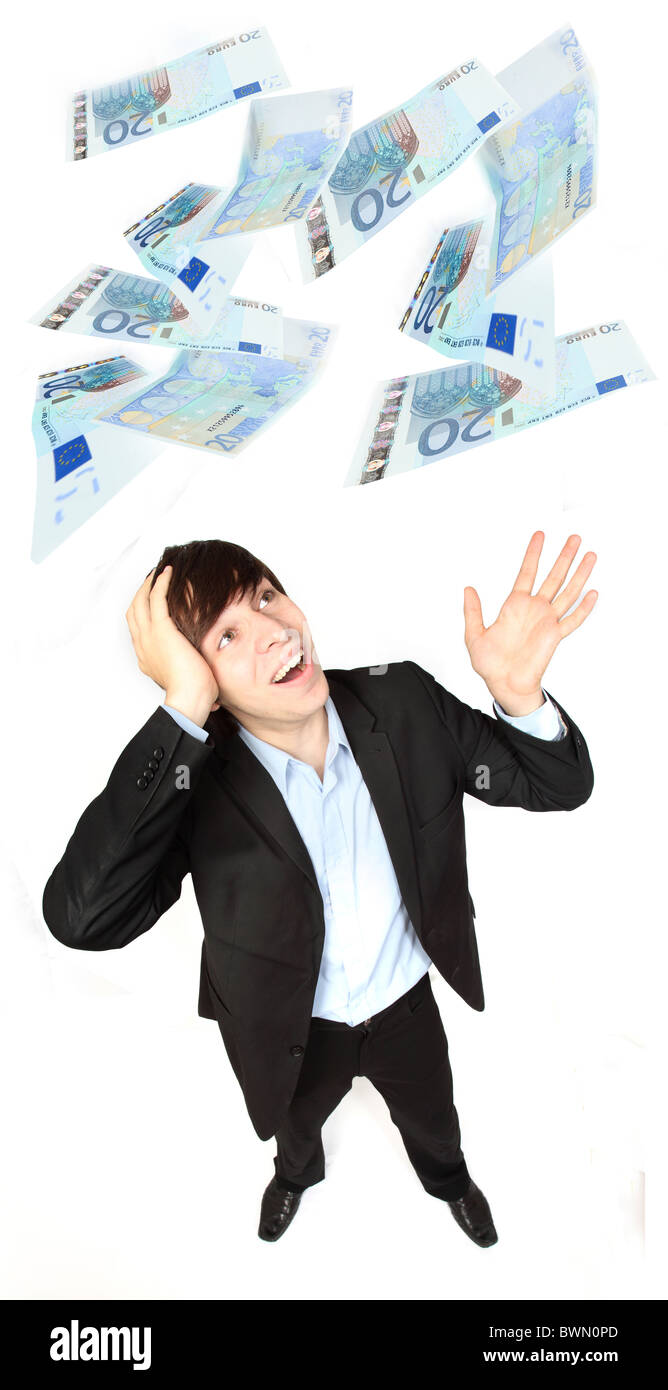 Young male wearing a suit, hand on his head amazed as Euros fall from above. Stock Photo