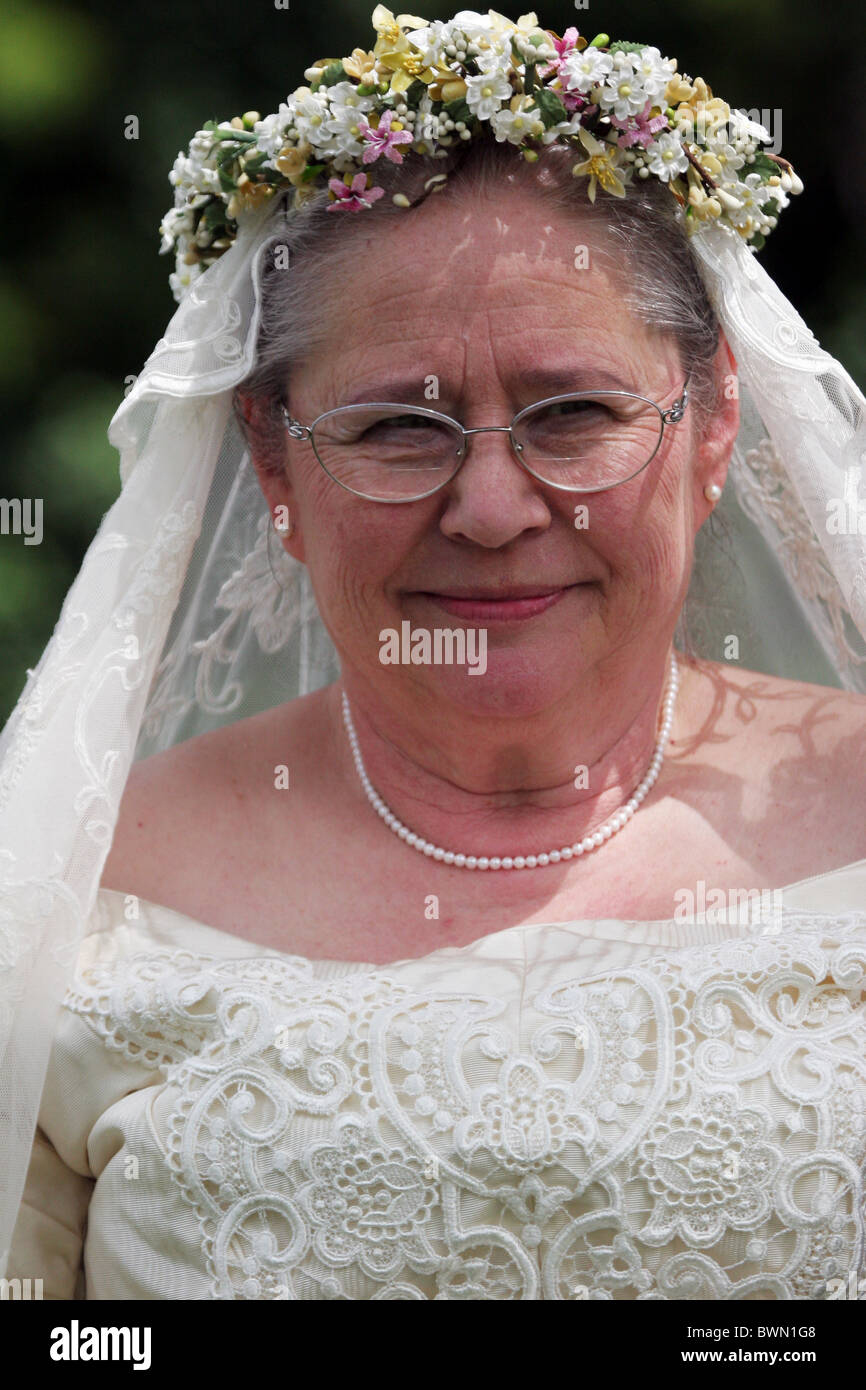 An WWII World War II era bride in an ivory silk and lace dress with a