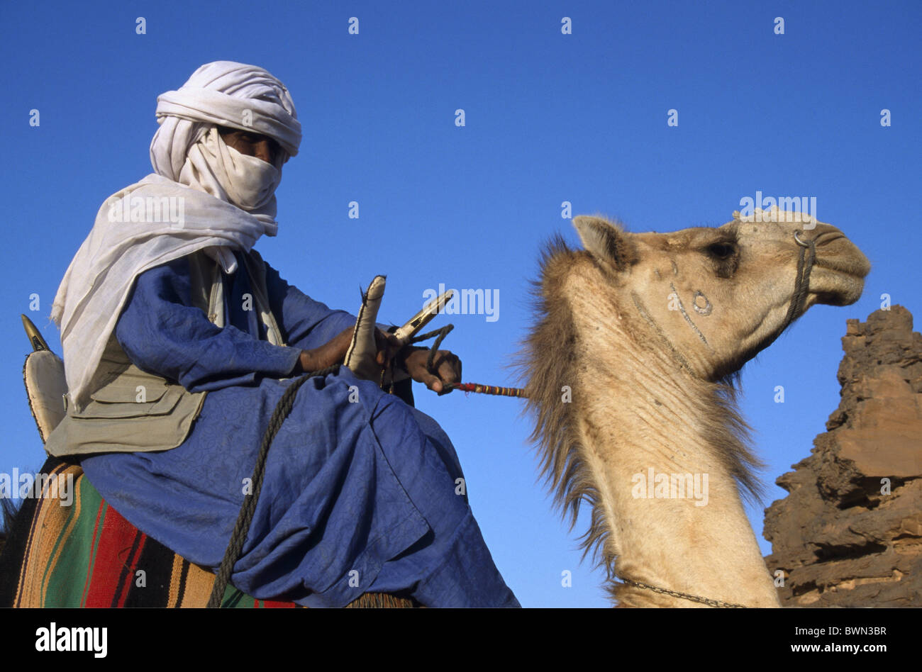 Libya Tuareg man camel rider riding oasis Um El Ma Mandara lakes Africa local man camels nomad nomads Sah Stock Photo