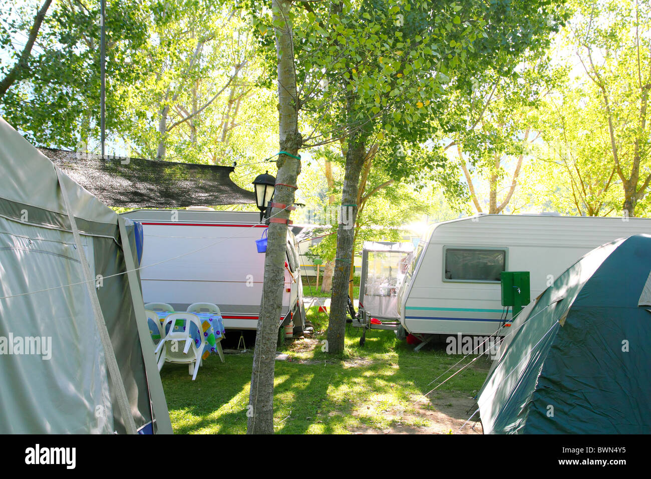 Camping tents caravan in green trees outdoor summer vacation Stock