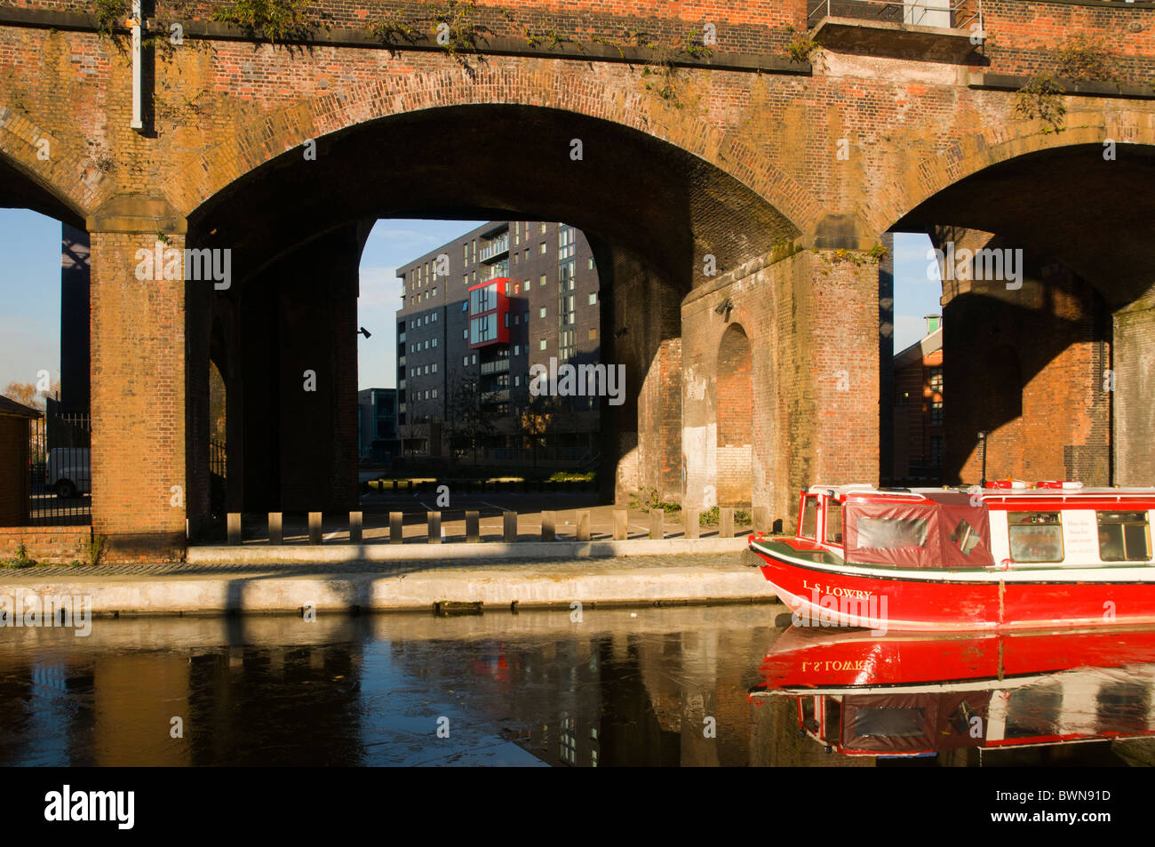 Victorian railway bridges and canal boat, at Potato Wharf, Castlefield Basin, Manchester, England, UK Stock Photo