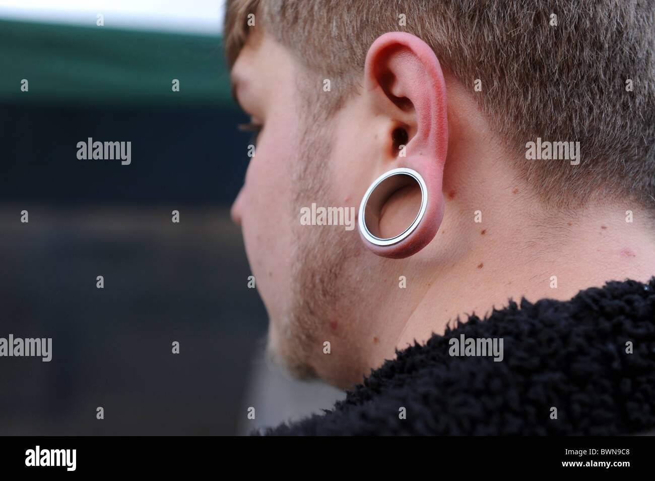 Young man wearing tribal earring Stock Photo