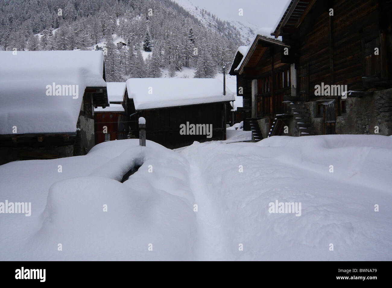 Switzerland Europe Canton Valais Goms Munster Winter snow snowbound mountain village Wooden houses wooden a Stock Photo