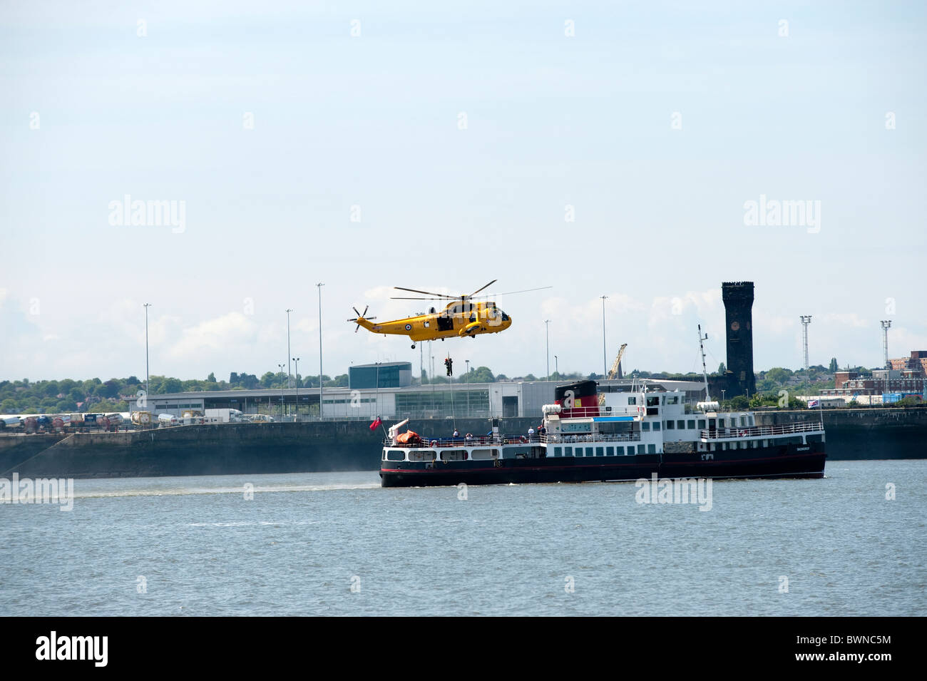 Seaking helicopter rescuing casualty from ferry boat Fire & Rescue Service UK Stock Photo