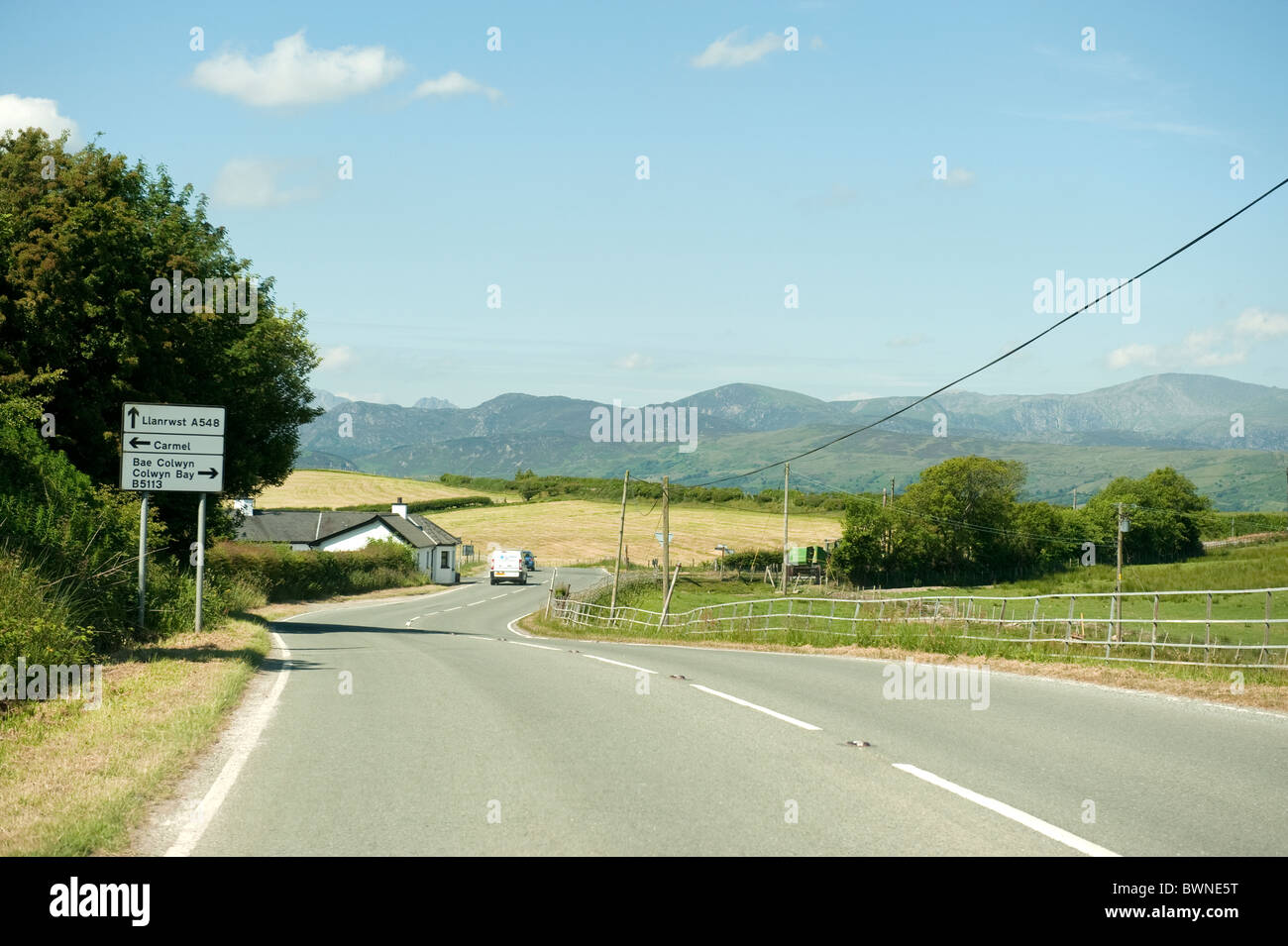 Road sign Llanrwst Carmel Colwyn Bay with Snowdonian Mountains  in background Stock Photo