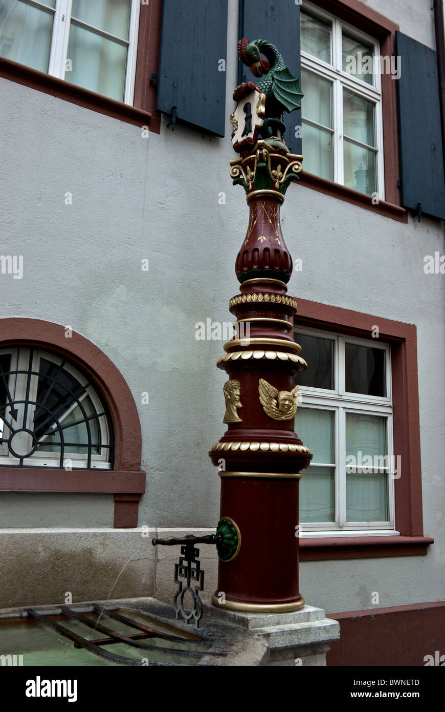 Potable water fountain featuring a dragon with chicken head and snake tail city's heraldic animal with drinking pool Basel Stock Photo