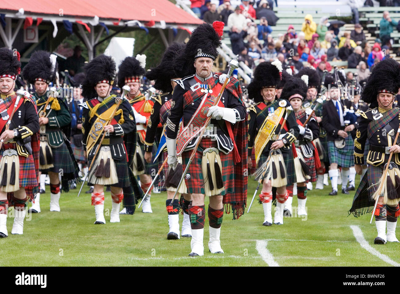 Marching massed pipe band with bagpipes at the Braemar Games Highland gathering Stock Photo