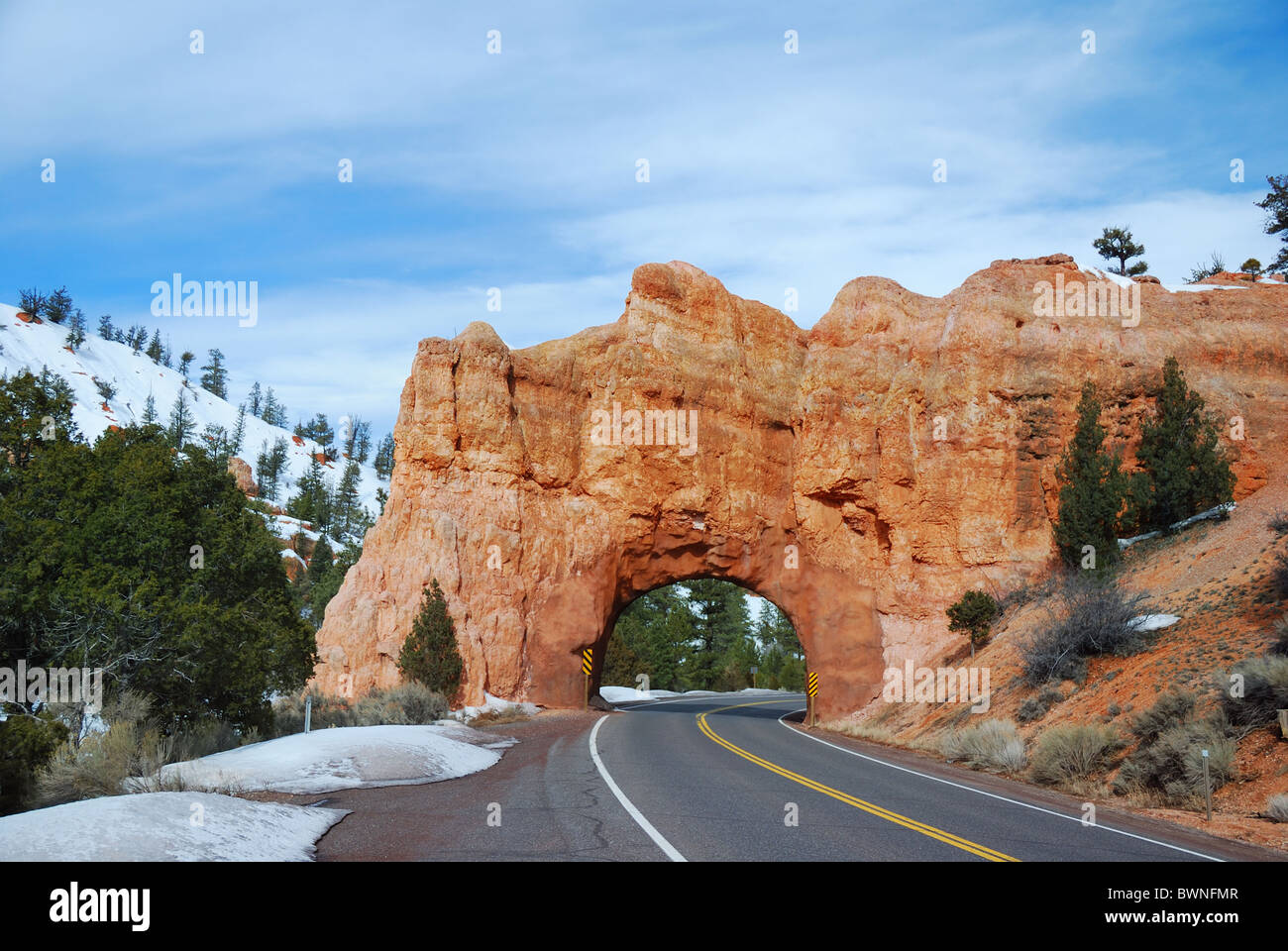 Stone gate in Bryce Canyon national park with snow and road across. Stock Photo
