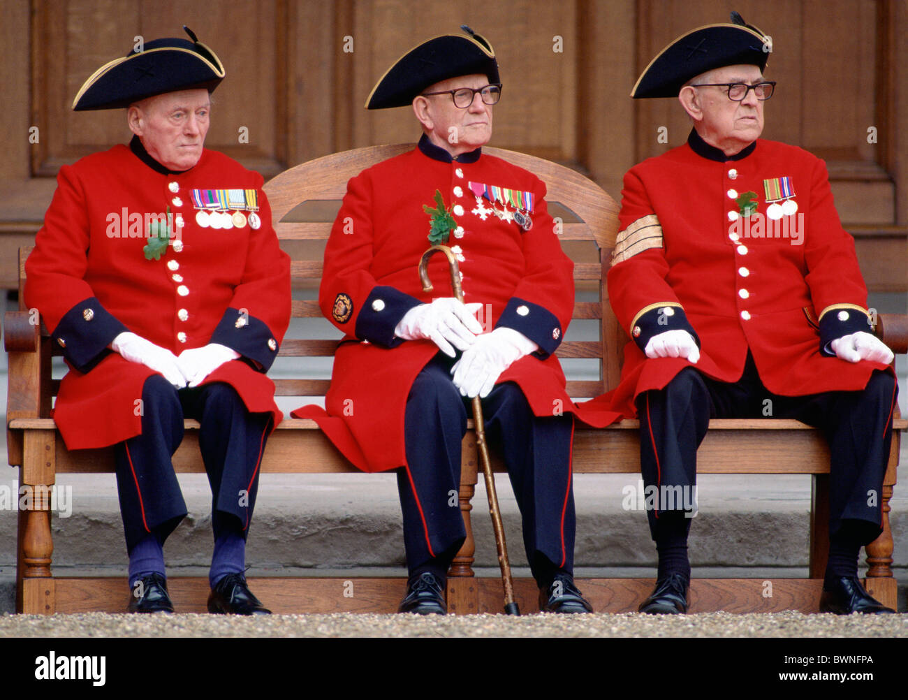 Chelsea Pensioners sitting outside the Royal Hospital in Chelsea during the Founder's Day Parade. Stock Photo