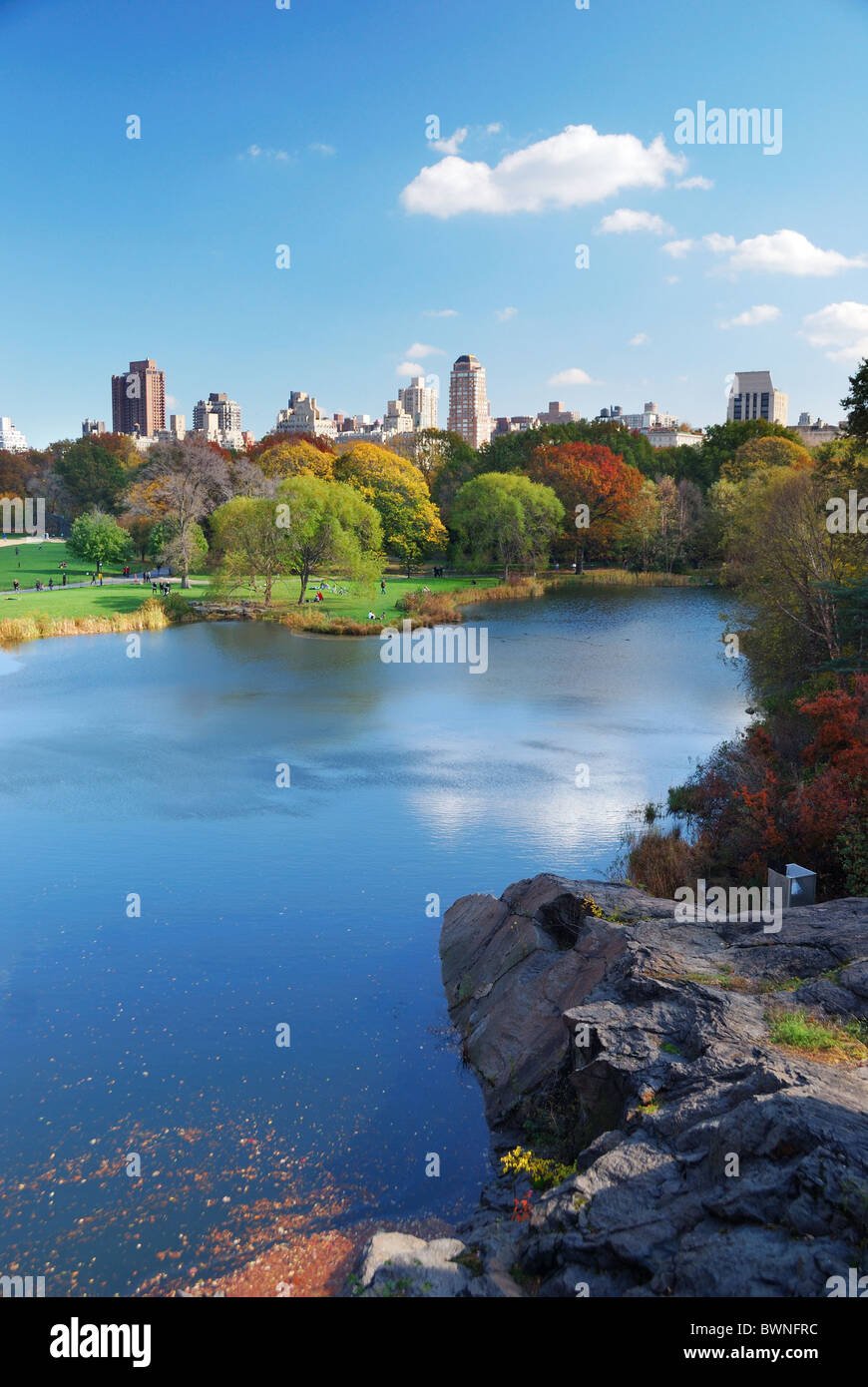 New York City Central Park in Autumn with Manhattan skyscrapers and colorful trees over lake with reflection. Stock Photo