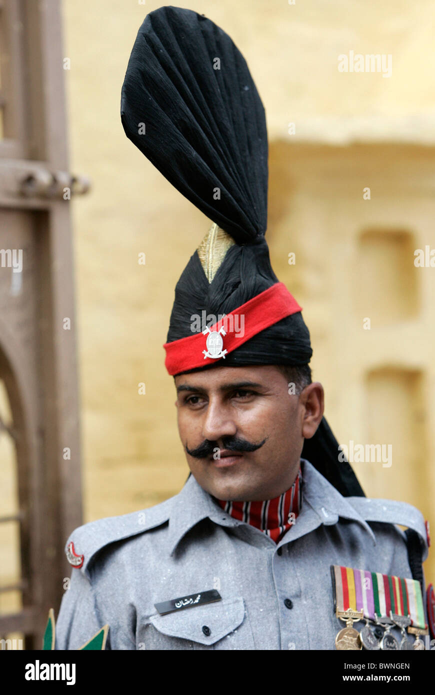 A Pakistani ceremonial guard stands outside the Sikh Temple Gurdwara of Arjan Dev in Lahore, Pakistan Stock Photo
