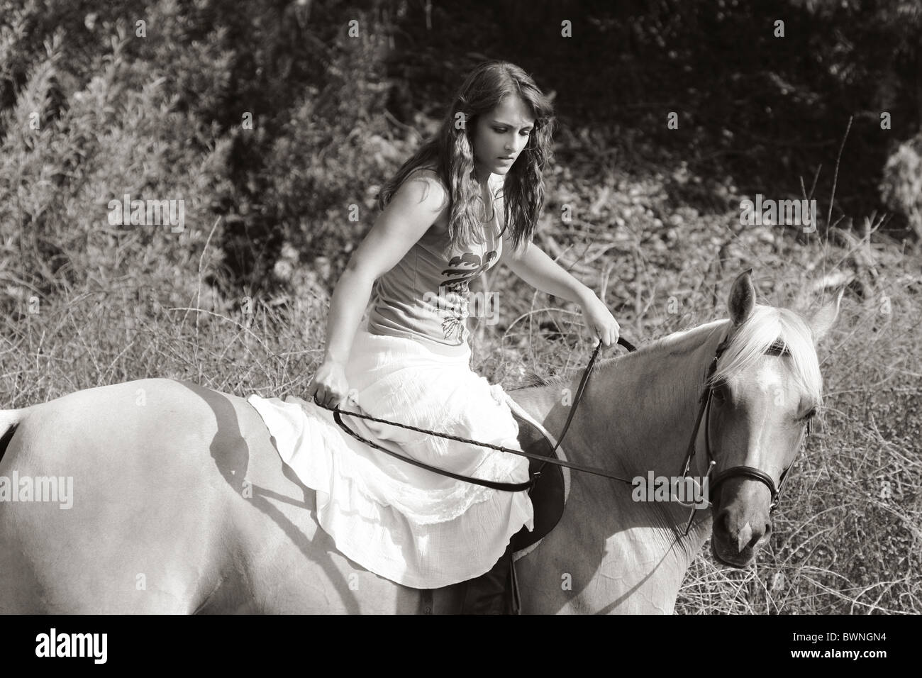 Attractive girl riding on horse in deserted rural location Stock Photo