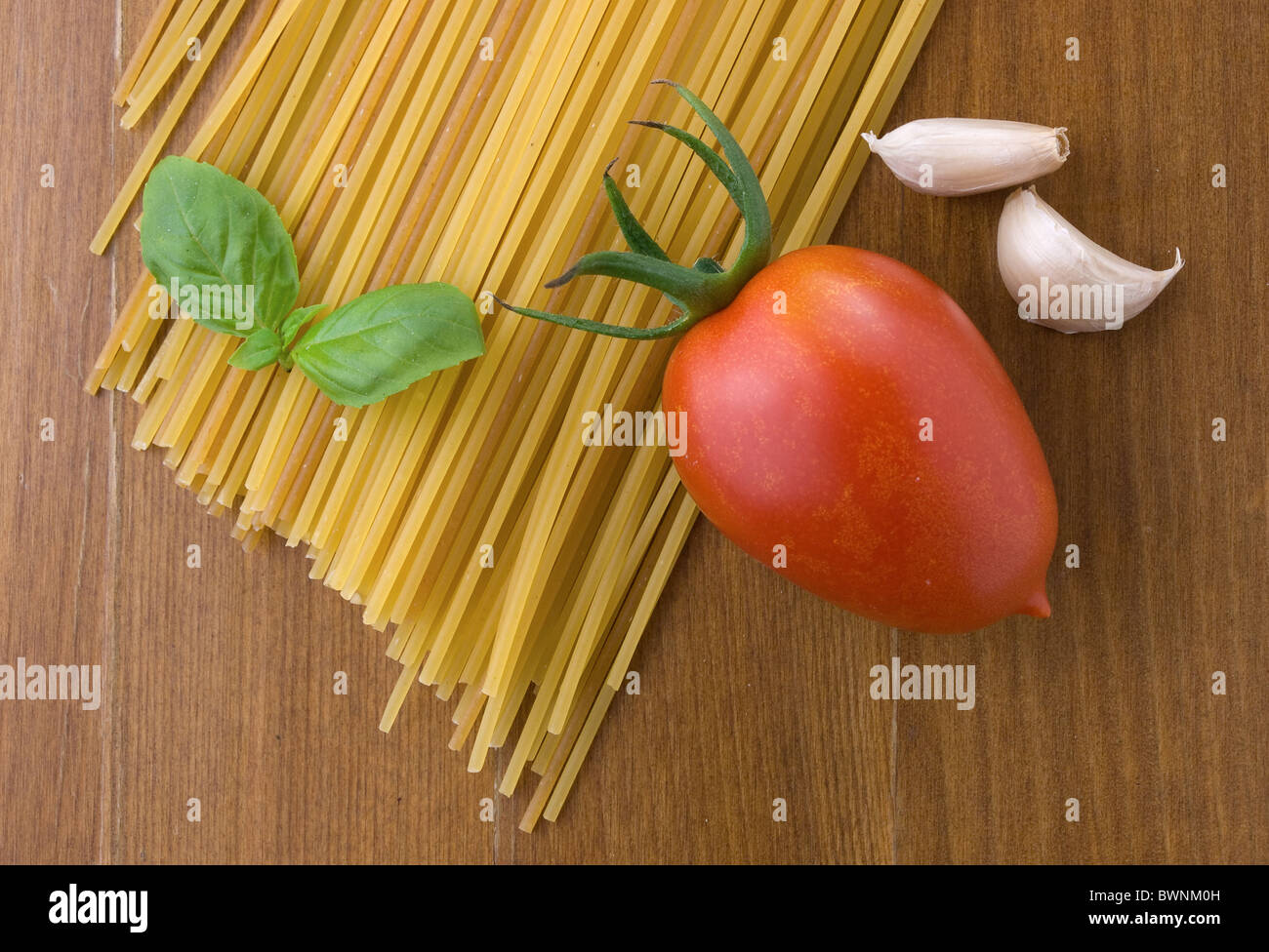 raw spaghetti  with tomato basil and garlic Stock Photo
