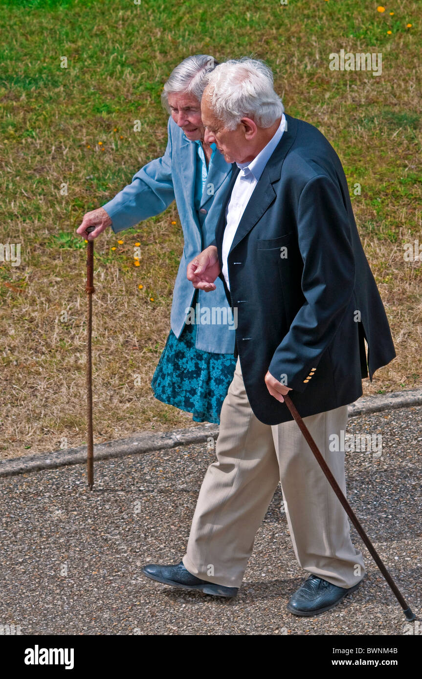 Mature / middle-aged couple walking along pavement - France. Stock Photo