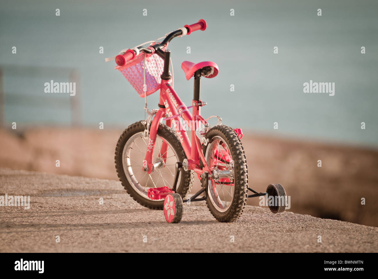 Pink girls bicycle with stabilizers Stock Photo