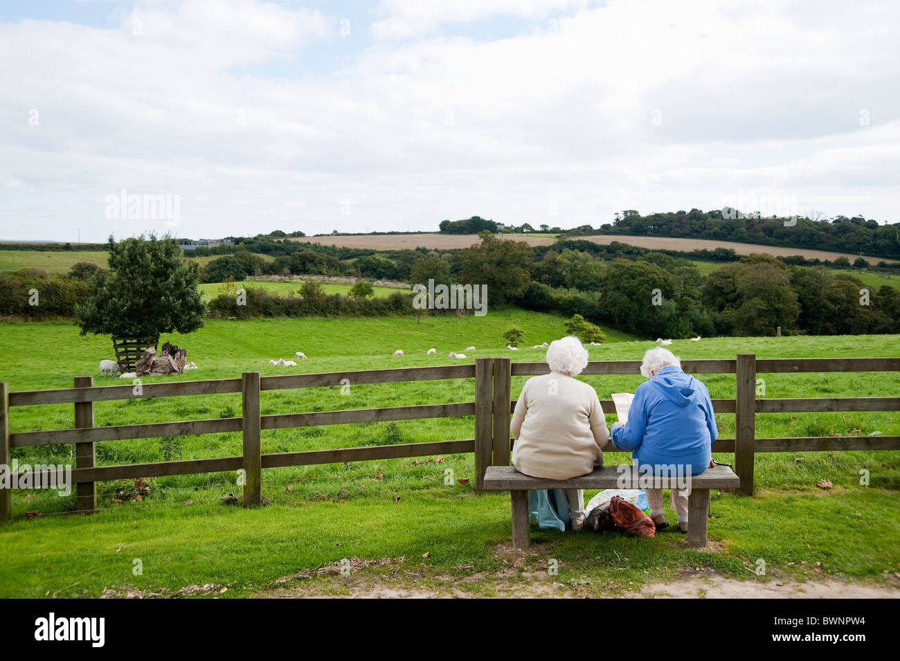 Two elderly woman resting on a bench,  Heligan and Lost Garden, Cornwall, UK Stock Photo