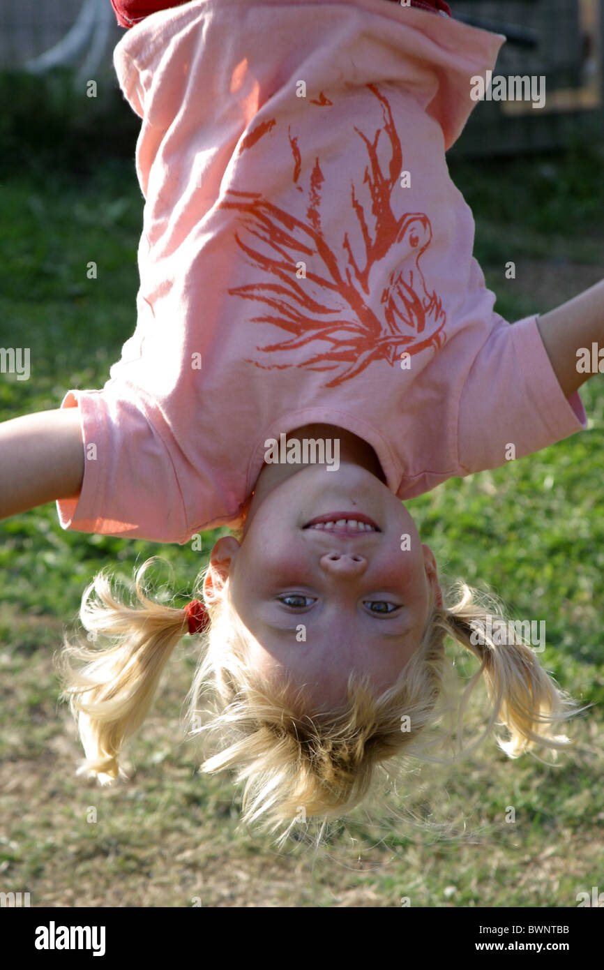 Toddler upside down on climbing frame, happy look at camera Stock Photo ...