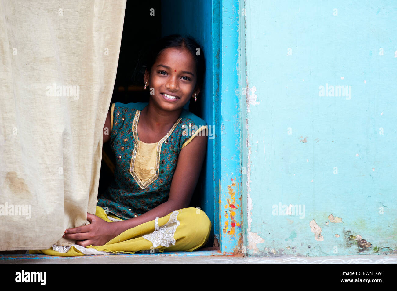 Smiling Happy Indian Village Girl Sitting In The Doorway Of - 