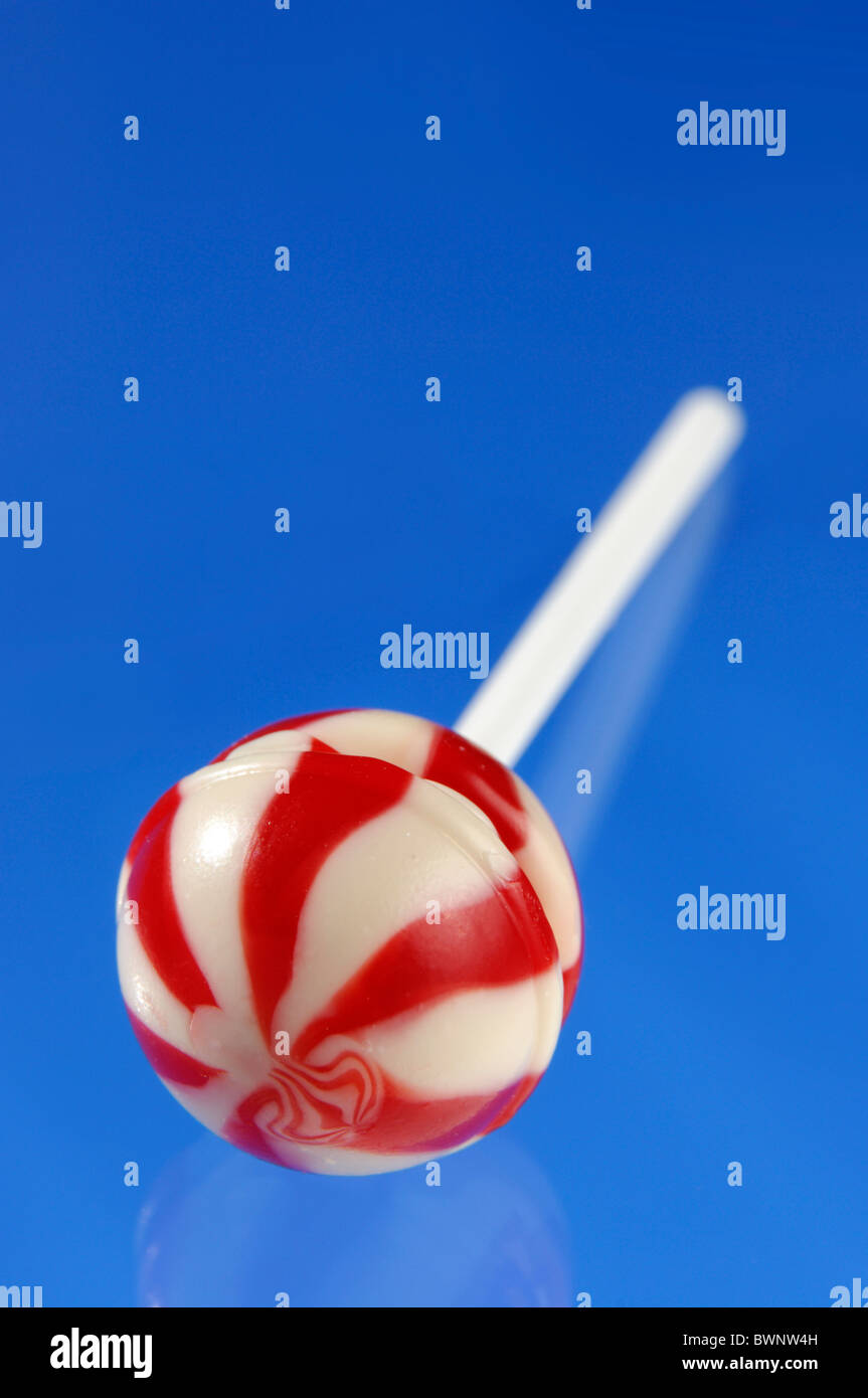 Colorful Red White Stripy Lollipop Isolated On Blue Background