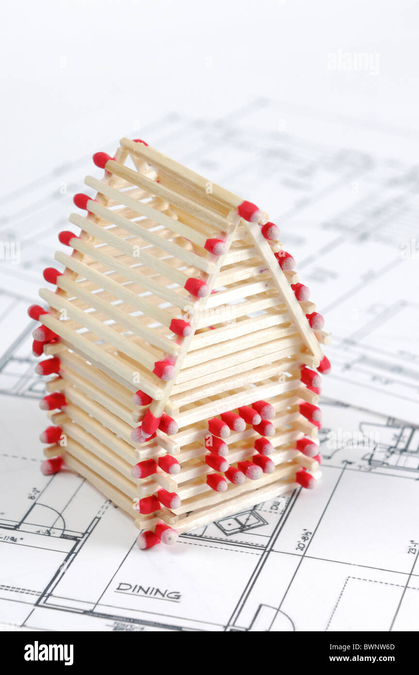 House made from matches standing on construction plans Construction
