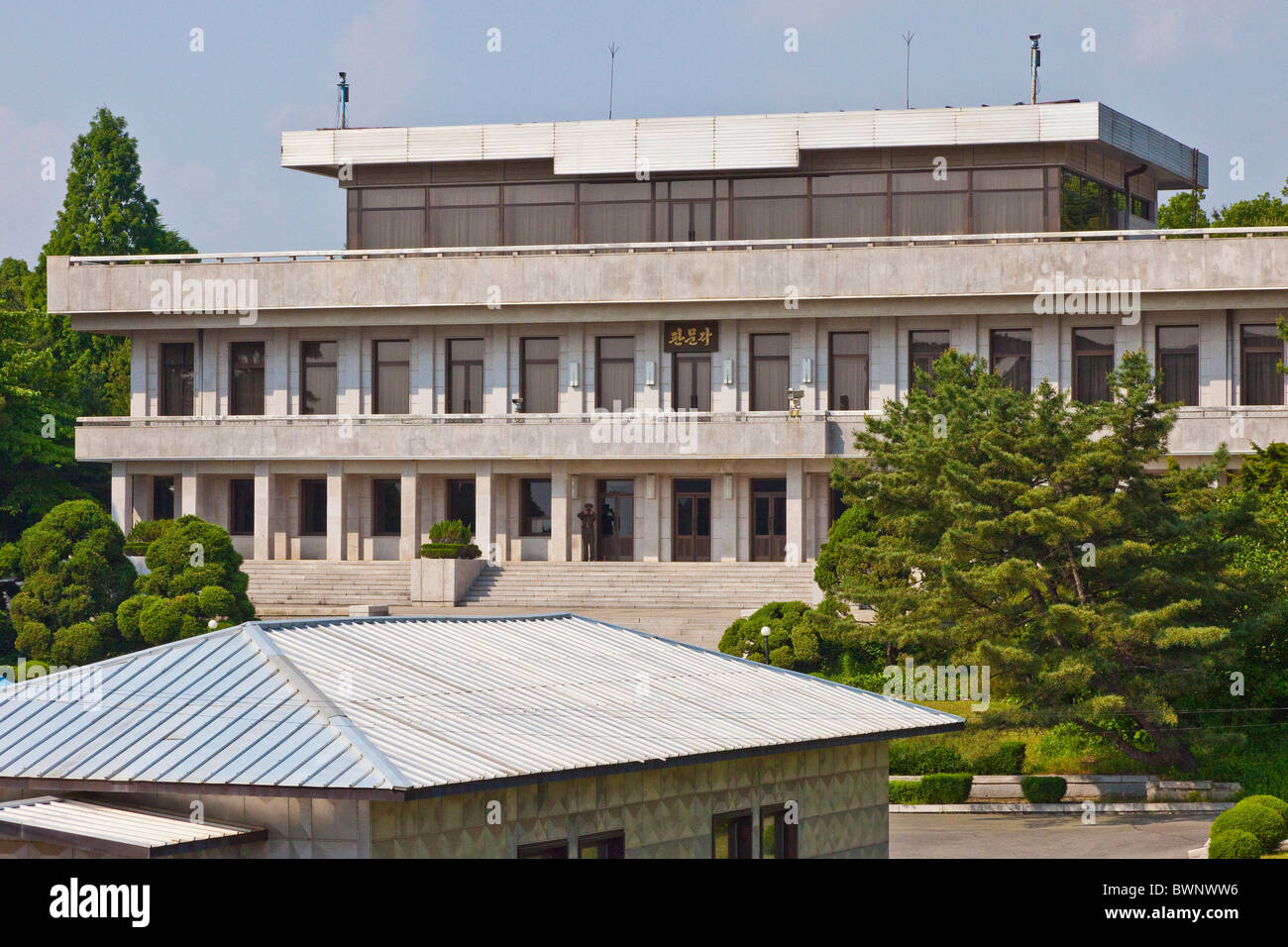 Panmon Hall North Korean building in DMZ Demilitarized Zone, with North Korean soldier, seen from South Korean side. JMH3834 Stock Photo