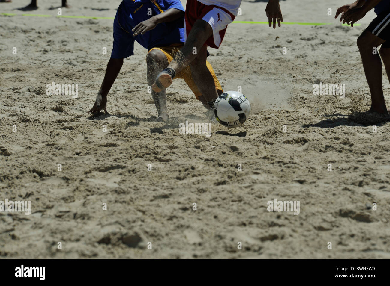 Feet of man kicking soccer ball playing beach Football action Movement