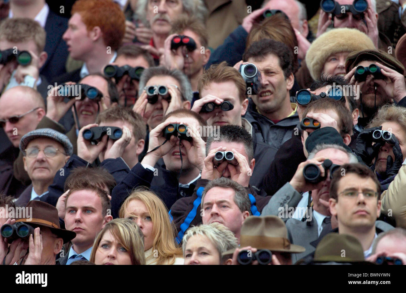 Crowds of spectactors with binoculars watching the National Hunt