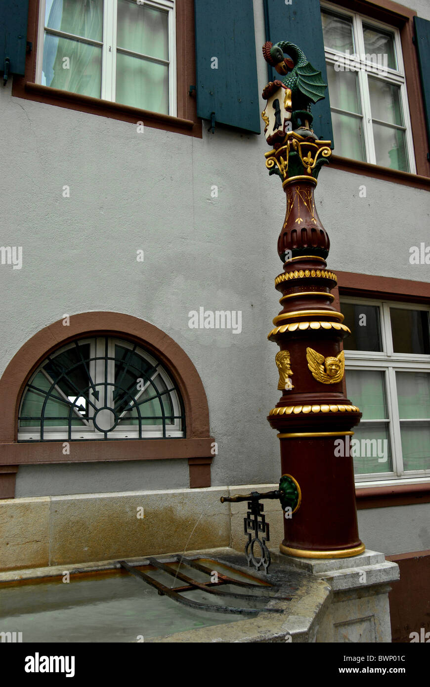 Potable water fountain featuring a dragon with chicken head and snake tail city's heraldic animal with drinking pool Basel Stock Photo