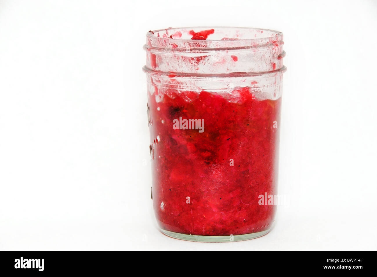 Leftover homemade cranberry sauce in glass jar. Stock Photo
