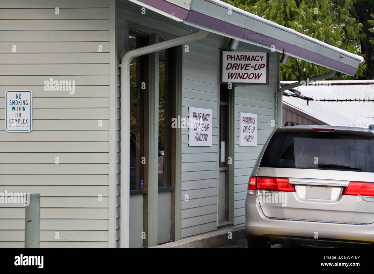 A customer in a car waits for a prescription at a pharmacy drive-up window in Olympia, Washington. Stock Photo