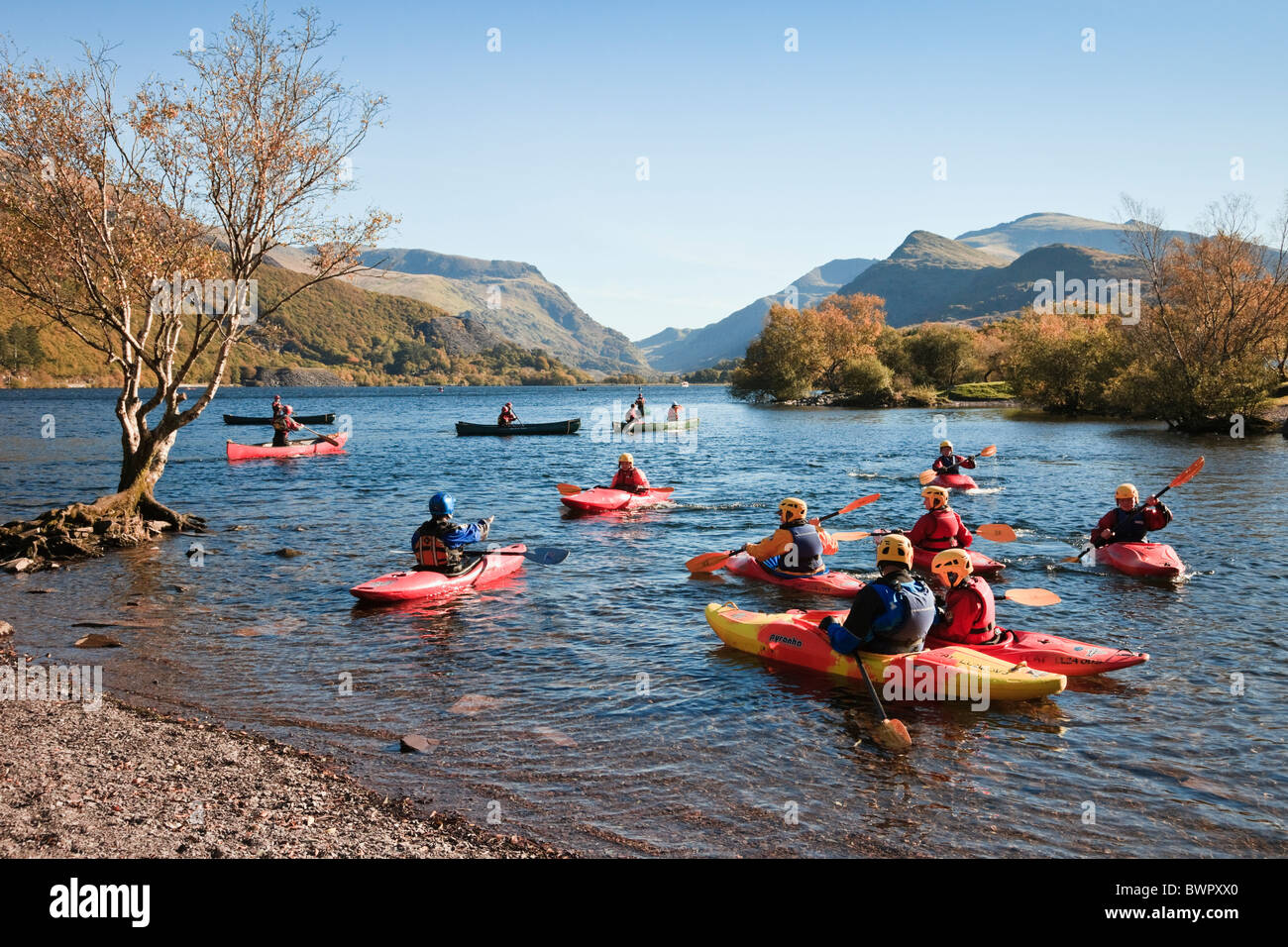 Young people learning kayaking in kayaks on Llyn Padarn Lake in