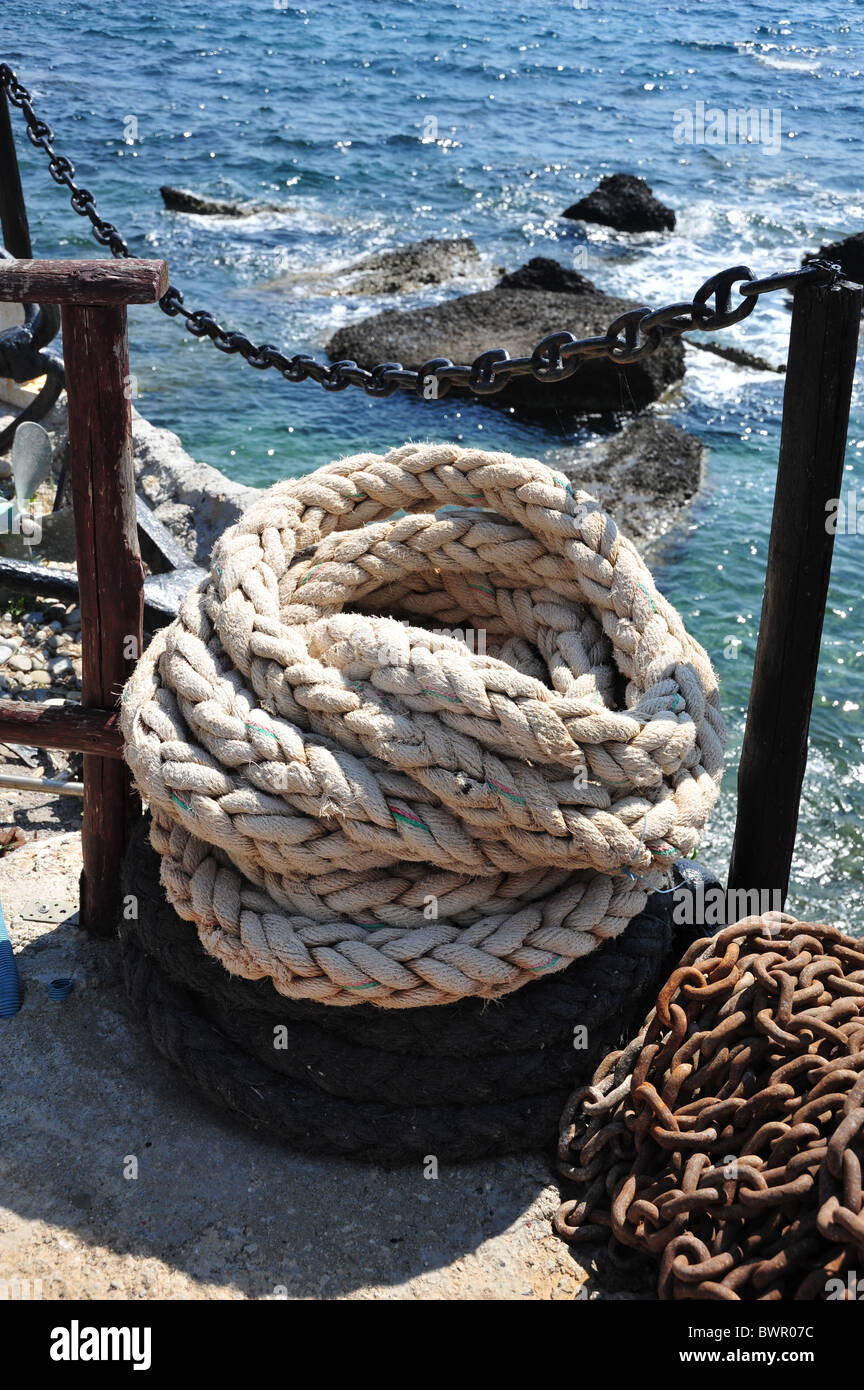 Mooring rope and chain on the harbour wall Stock Photo
