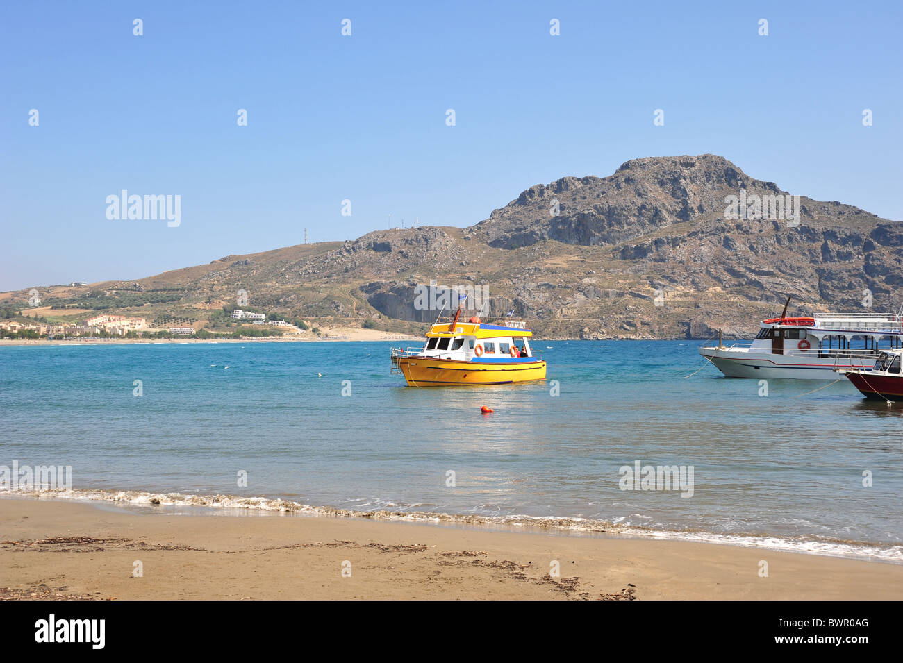 Plakias beach in Crete, Greece. Passenger ships are moored waiting to take visitors to Prevali. Stock Photo