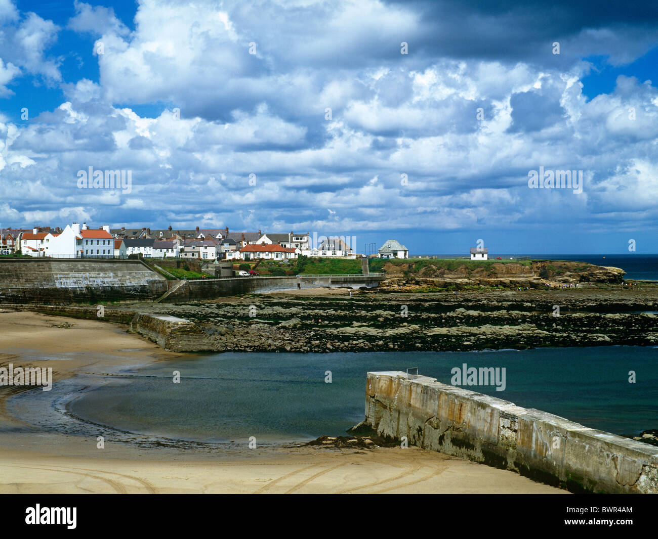 A view in summer of Cullercoats Harbour and Village in North Tyneside Stock Photo
