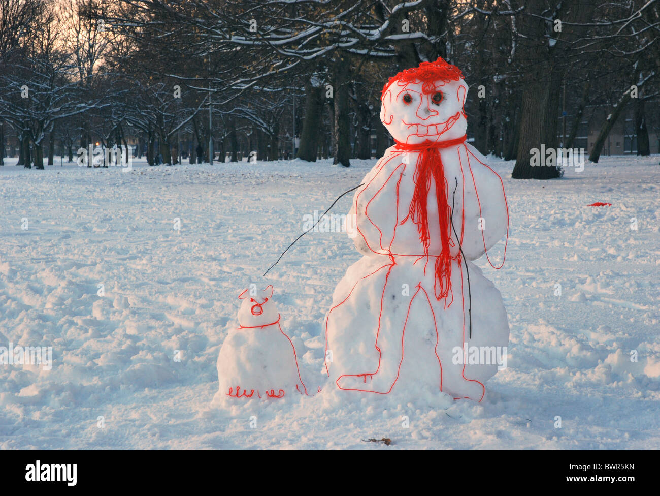 A 'cartoon' snowman with his dog, made from snow and wool, standing in the Meadows in Edinburgh, Scotland, UK. Stock Photo