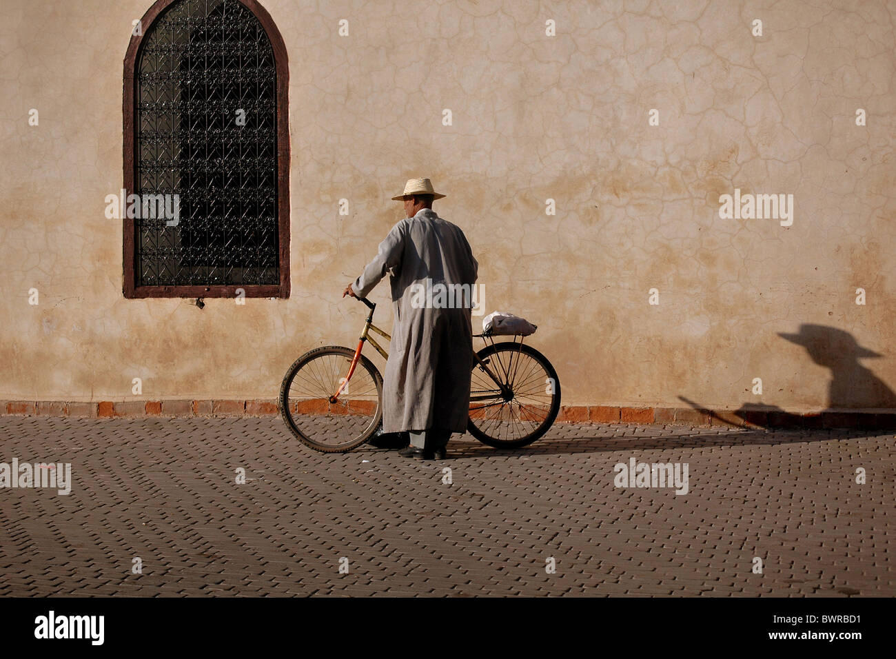Man on bike leaving the Ali ben Youssef Mosque in Marrakesh Stock Photo
