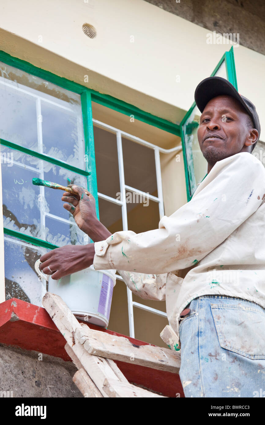 Workman painting at Maji Mazuri Centre and School, Nairobi, Kenya Stock Photo