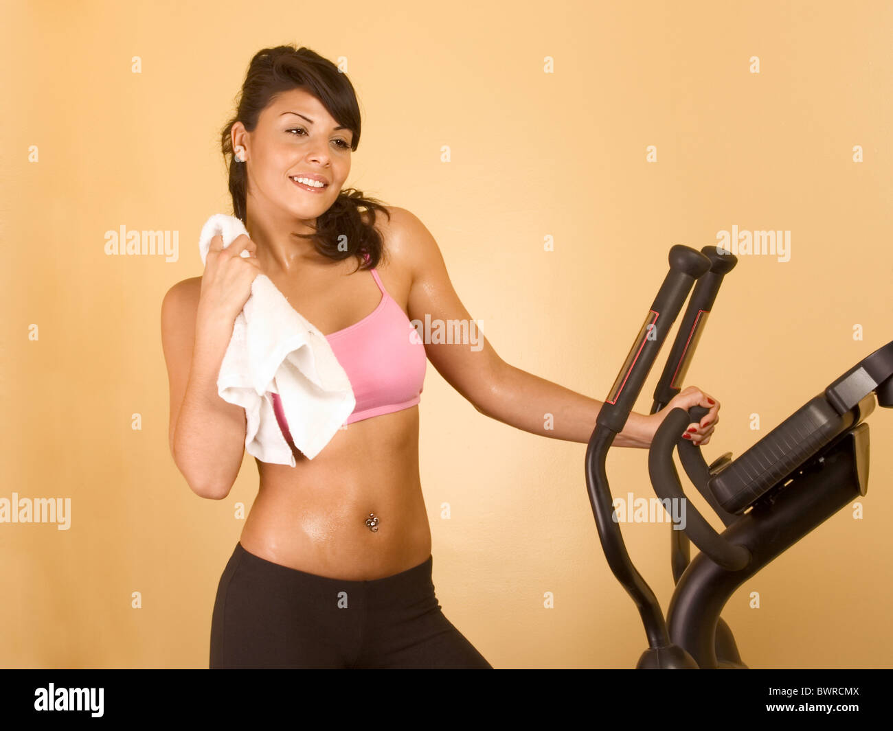 Young woman with towel resting after treadmill work out Stock Photo