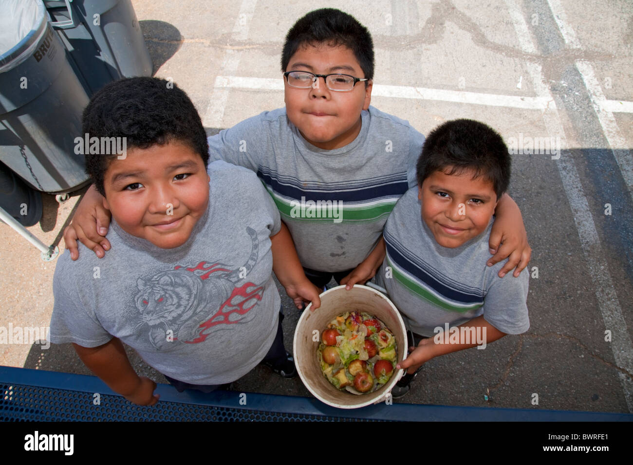Young boys collect food for the worm compost bin after class mates eat their lunch at the Downtown Value School, Los Angeles Stock Photo