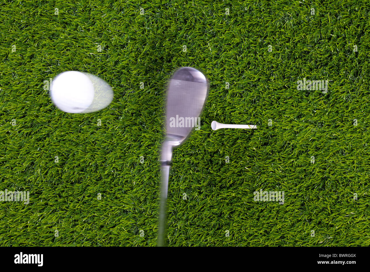 Photo of an iron hitting a golf ball off the tee with motion blur on