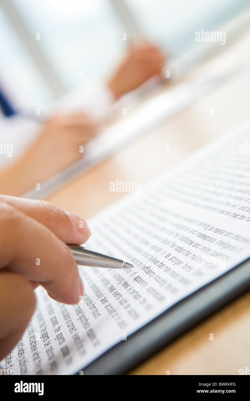 Vertical image of human hand holding pen and making notes Stock Photo ...