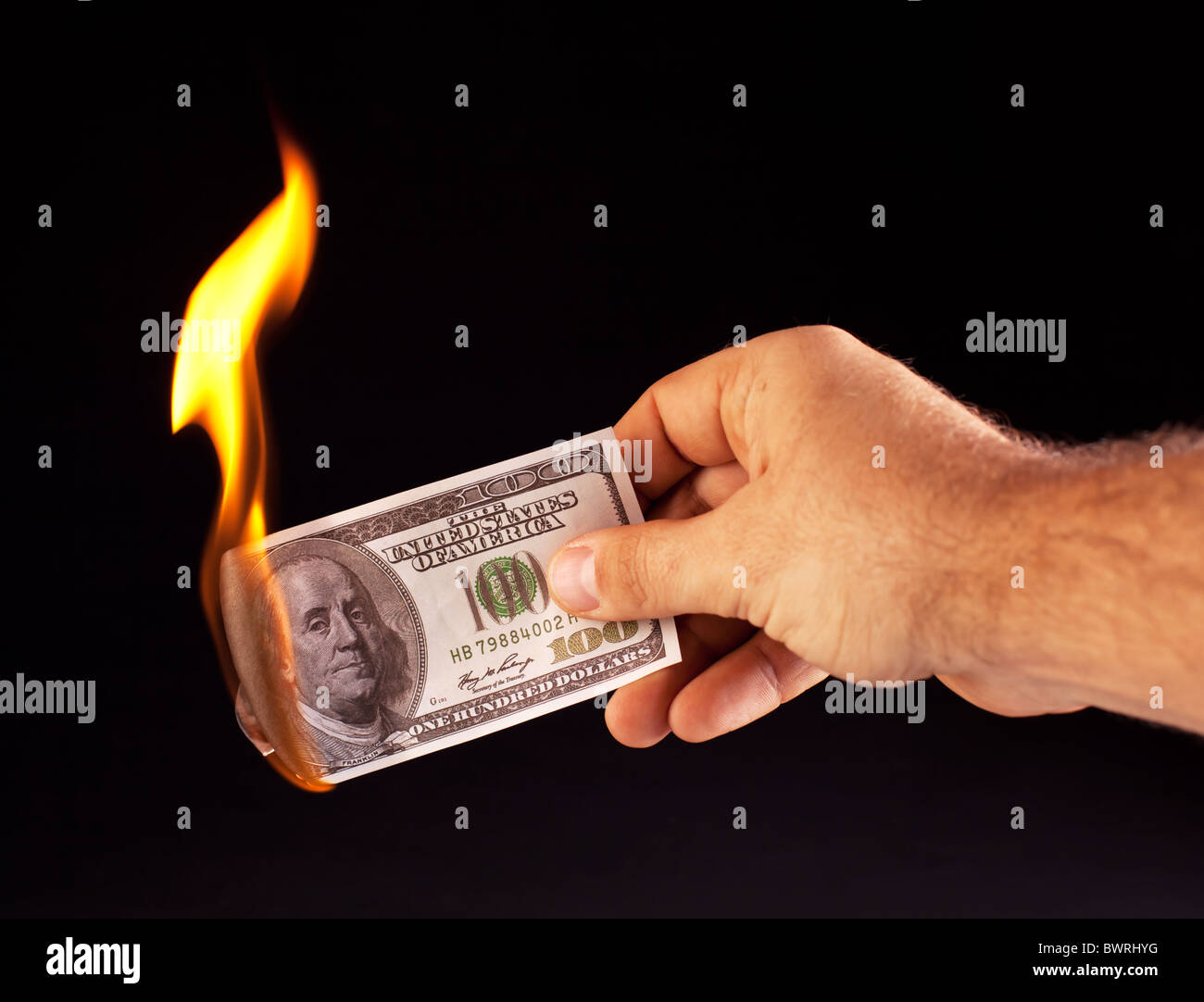 burning dollar in hand isolated on a black Stock Photo
