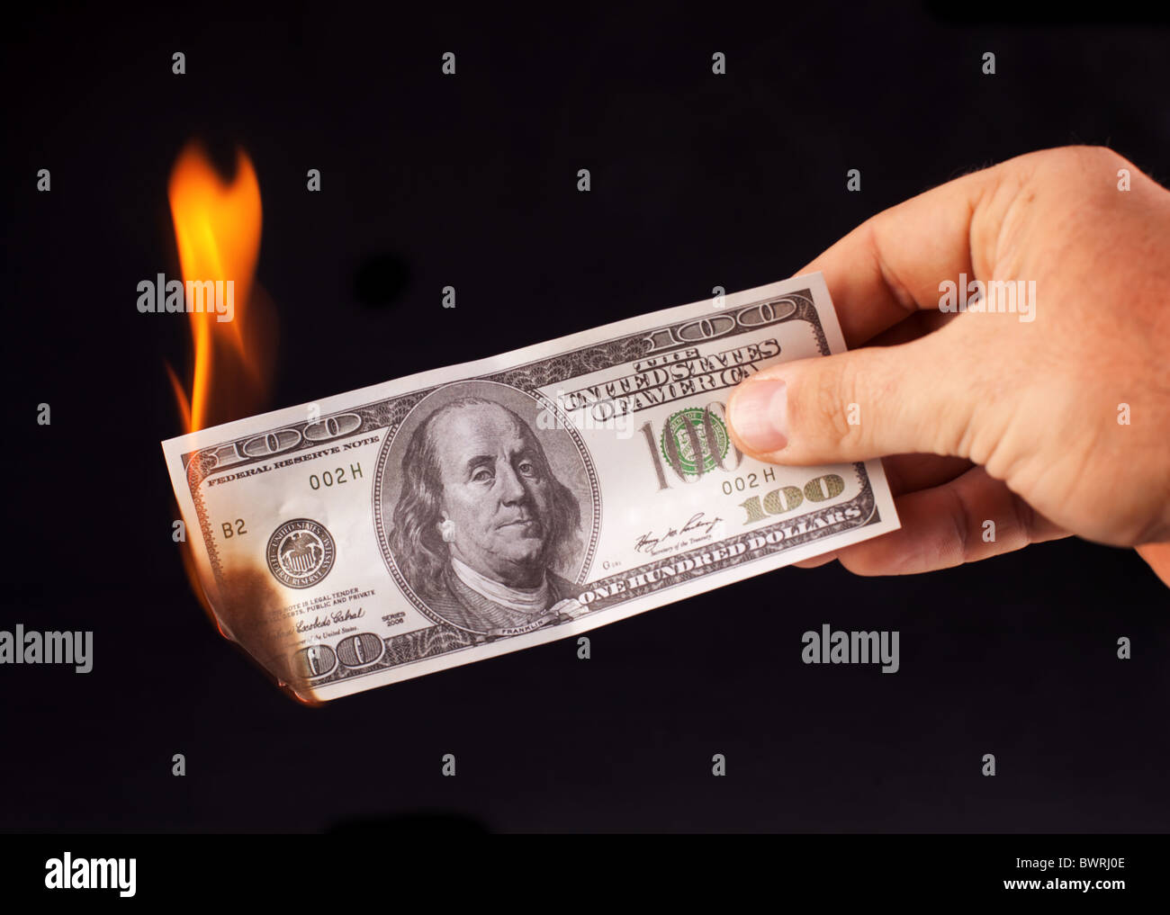 burning dollar in hand isolated on a black Stock Photo