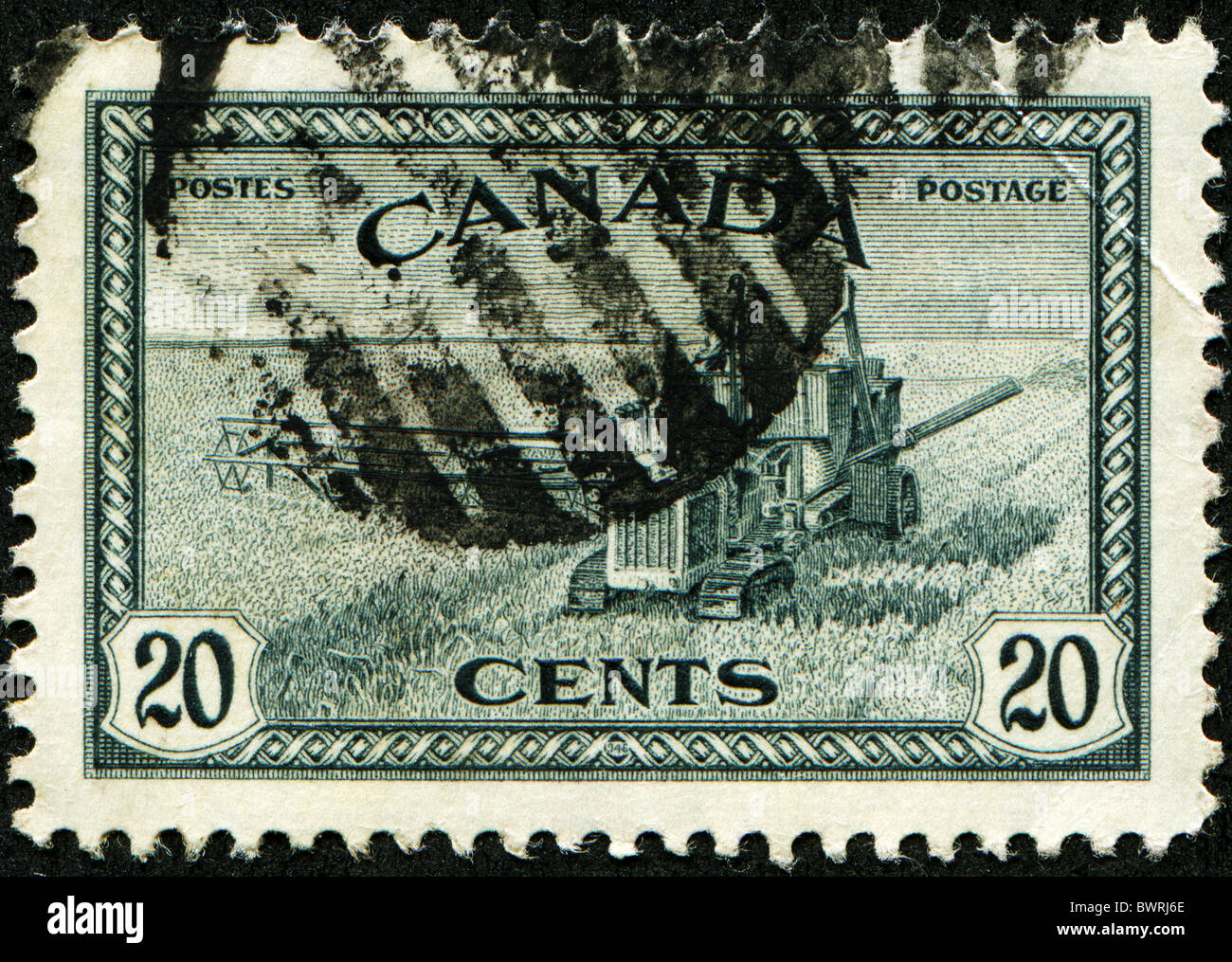CANADA - CIRCA 1933: A stamp printed in Canada shows Wheat harvest and 1930s style combine, circa 1933 Stock Photo