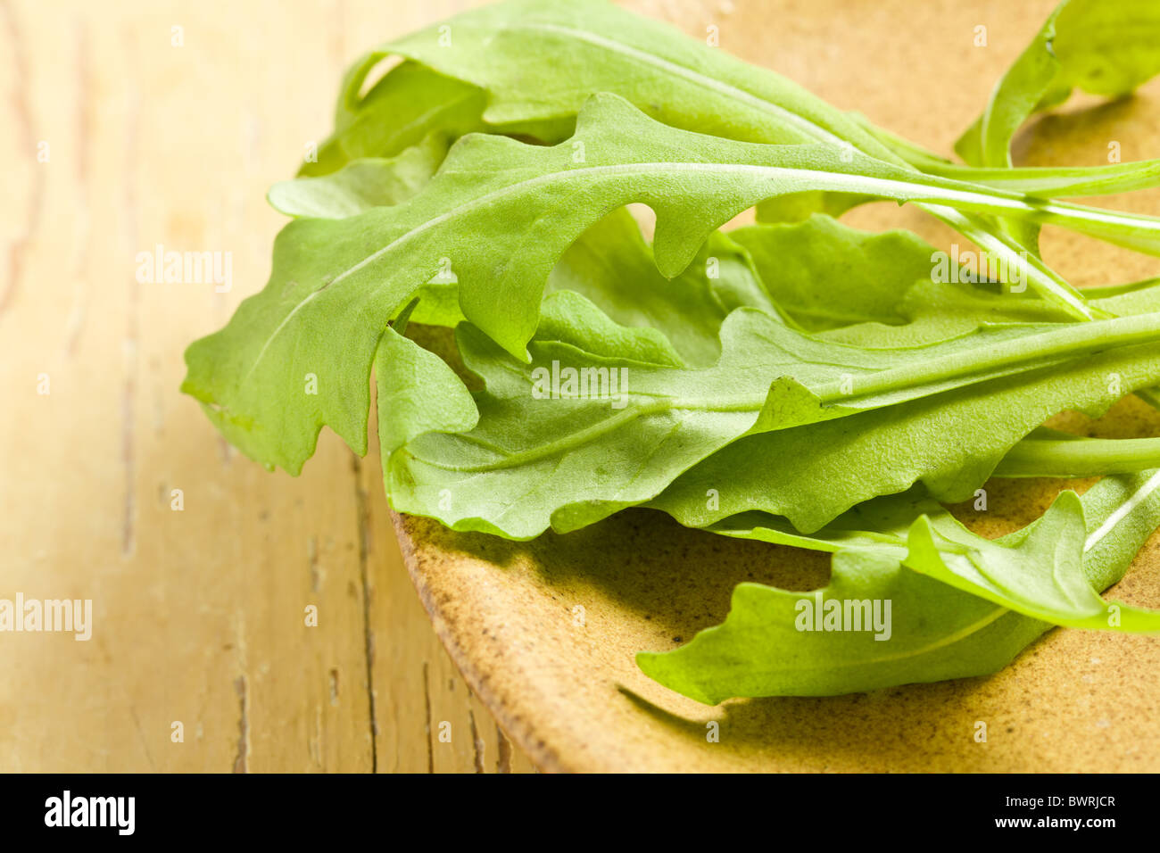 arugula leaves on wooden table Stock Photo