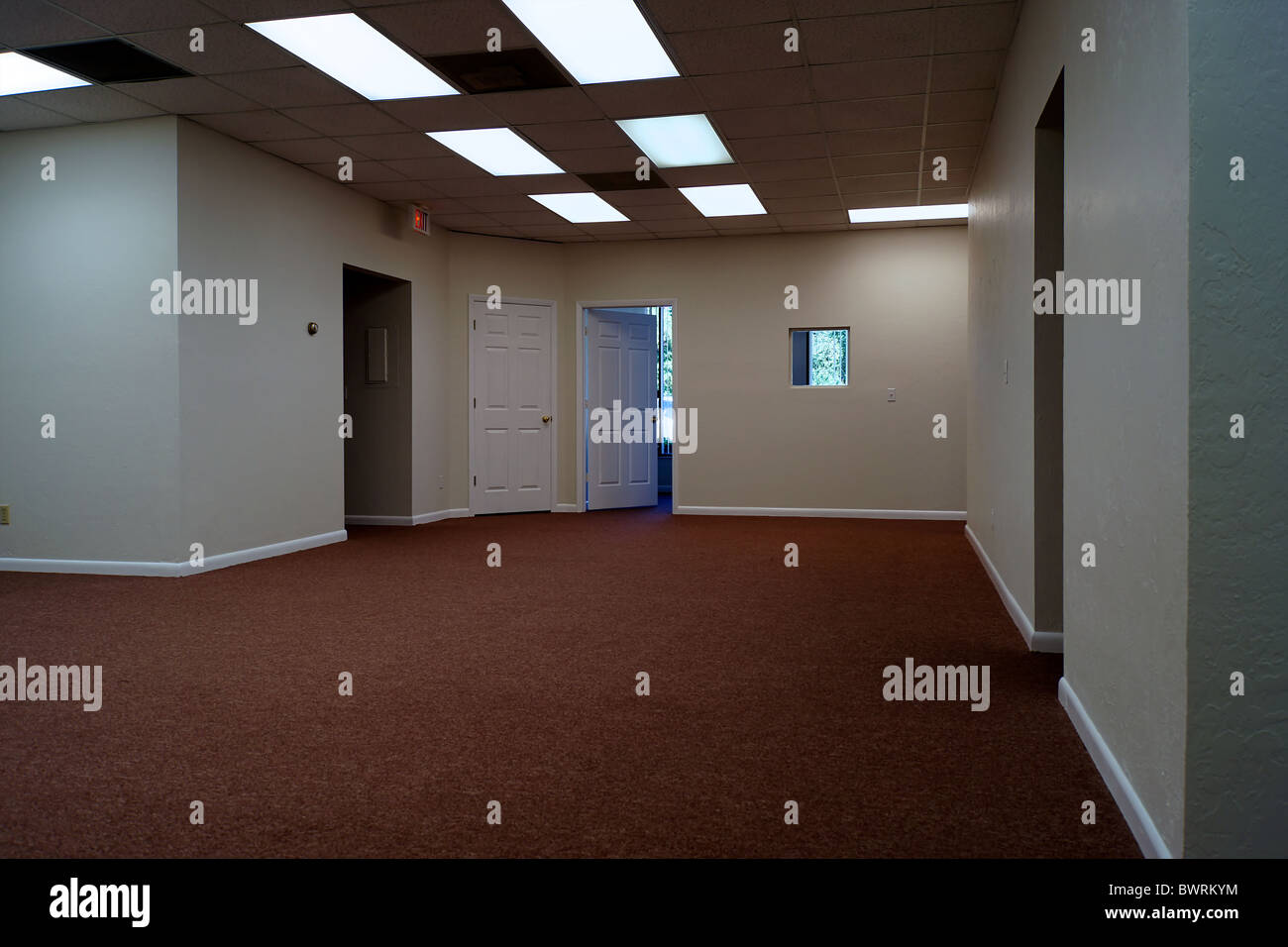 Large Empty Room With Blank Walls A Dark Hallway And Doors