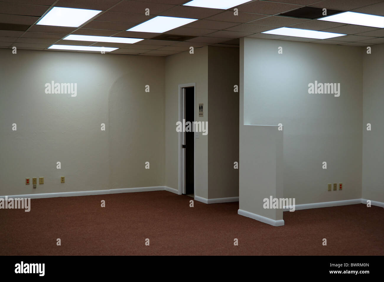 Inside Empty Office Space Lit By Fluorescent Ceiling Light