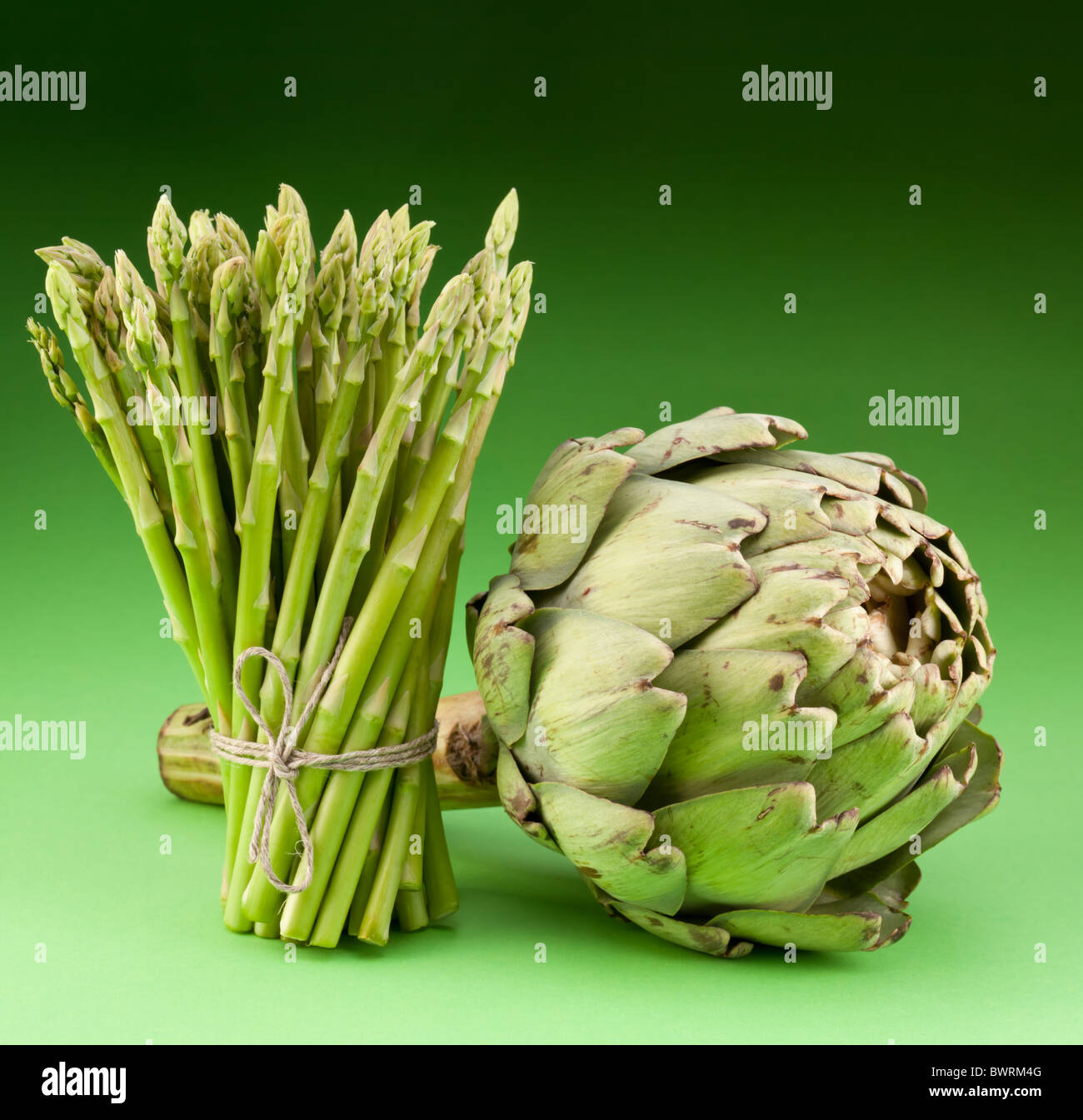 Artichoke and asparagus on a green background Stock Photo Alamy