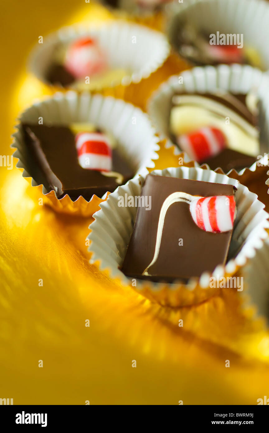 Double Chocolate Peppermint Bark broken in pieces and placed inside mini foil cups on a golden platter. Stock Photo