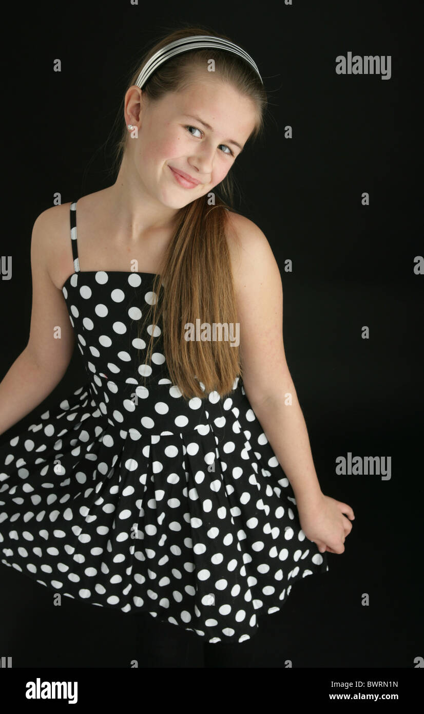 Ten year old girl wearing a polka dot dress and a headband. Stock Photo